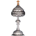 Silver ciborium with elements in relief and golden Cross