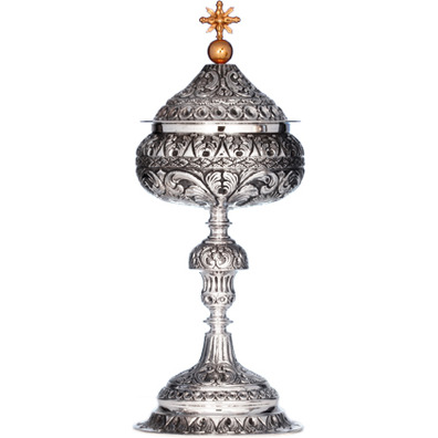 Silver ciborium with elements in relief and golden Cross
